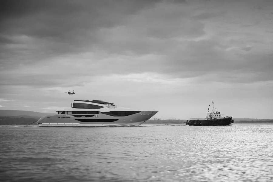 Die Sunseeker 134 Superyacht in Fahrt vor der Küste von Dorset, mit Schlepper und Hubschrauber